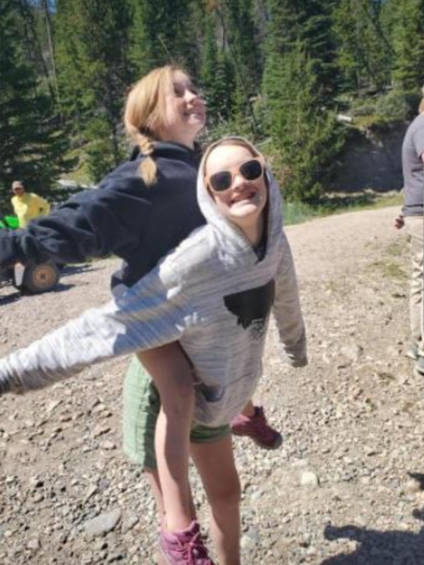 This picture was taken in front of a beautiful lake and i'm the one in the green shorts and my friend is the one on my back. My dad is photobombing the picture(he is the one in the yellow shirt.) then my friends dad is also photobombing the photo and he is the one with the gloves sticking out of his pocket